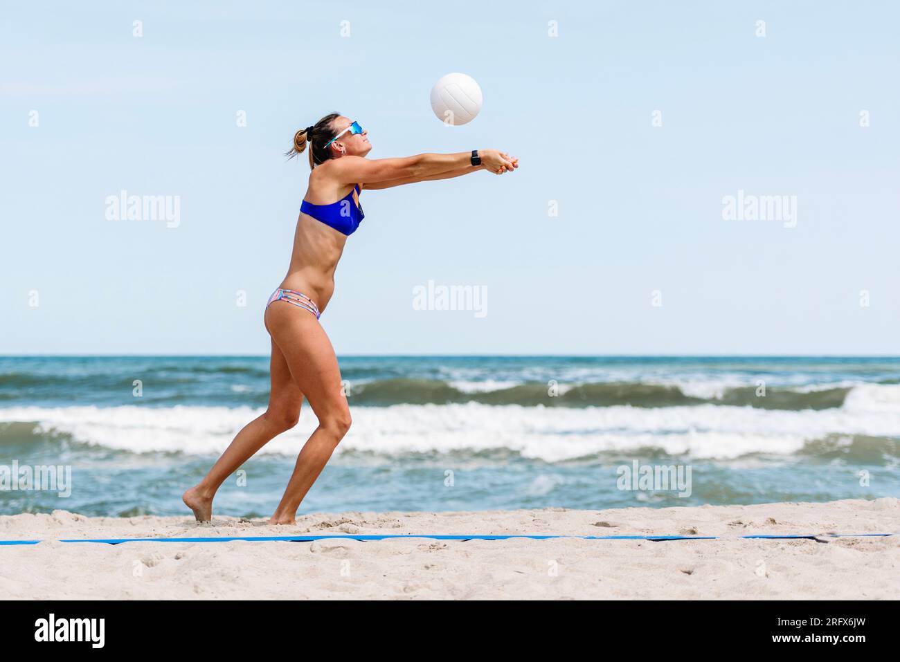 Professionelle Spielerin, die am Strand Volleyball spielt. Horizontales Sportposter, Grußkarten, Kopfzeilen, Website und App Stockfoto