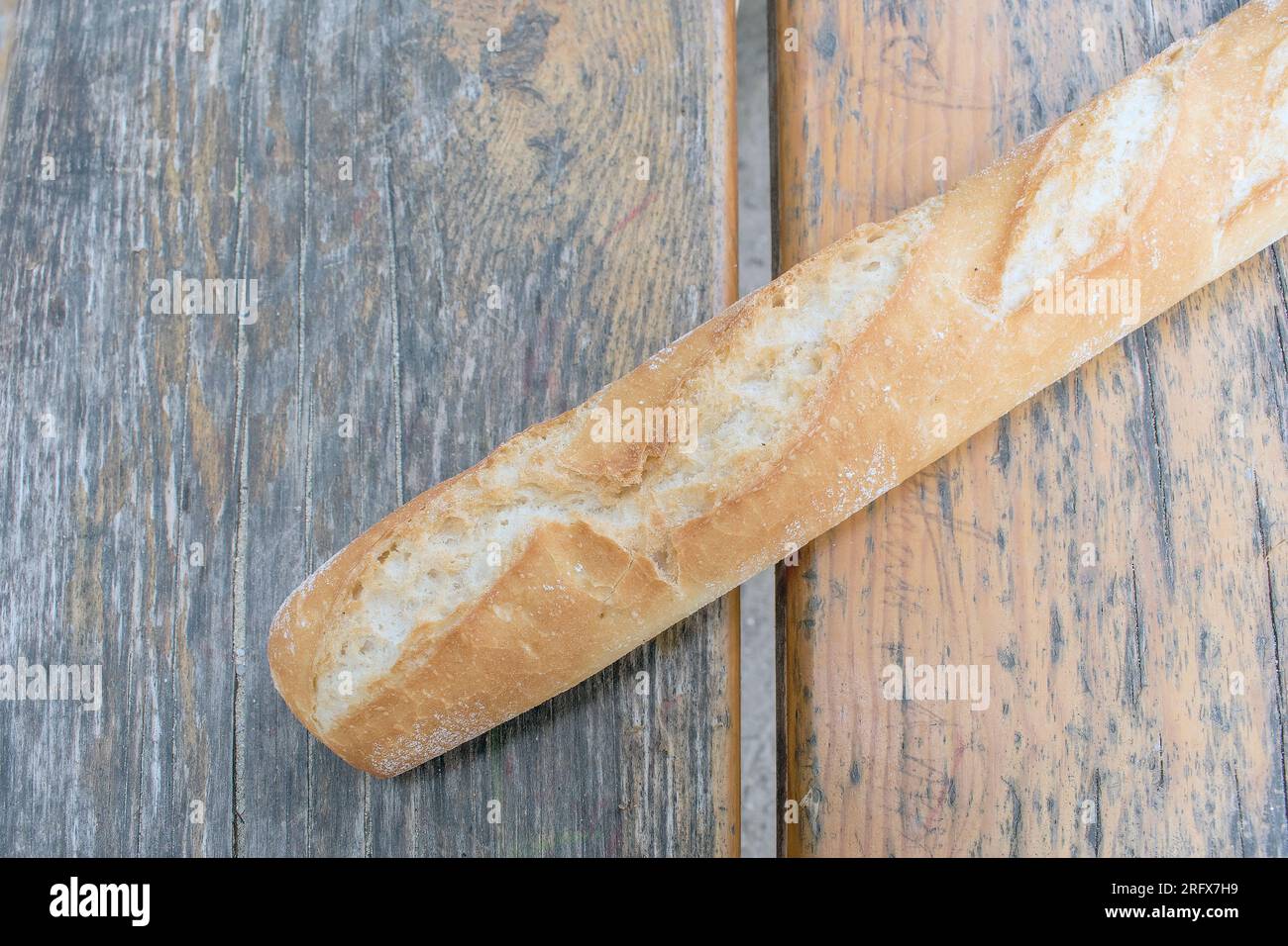 Crispy Baguette: Ein wunderbares Foto mit einem langen, knusprigen Baguette auf einem Tisch. Perfekt für Freizeit- und Outdoor-Dini Stockfoto