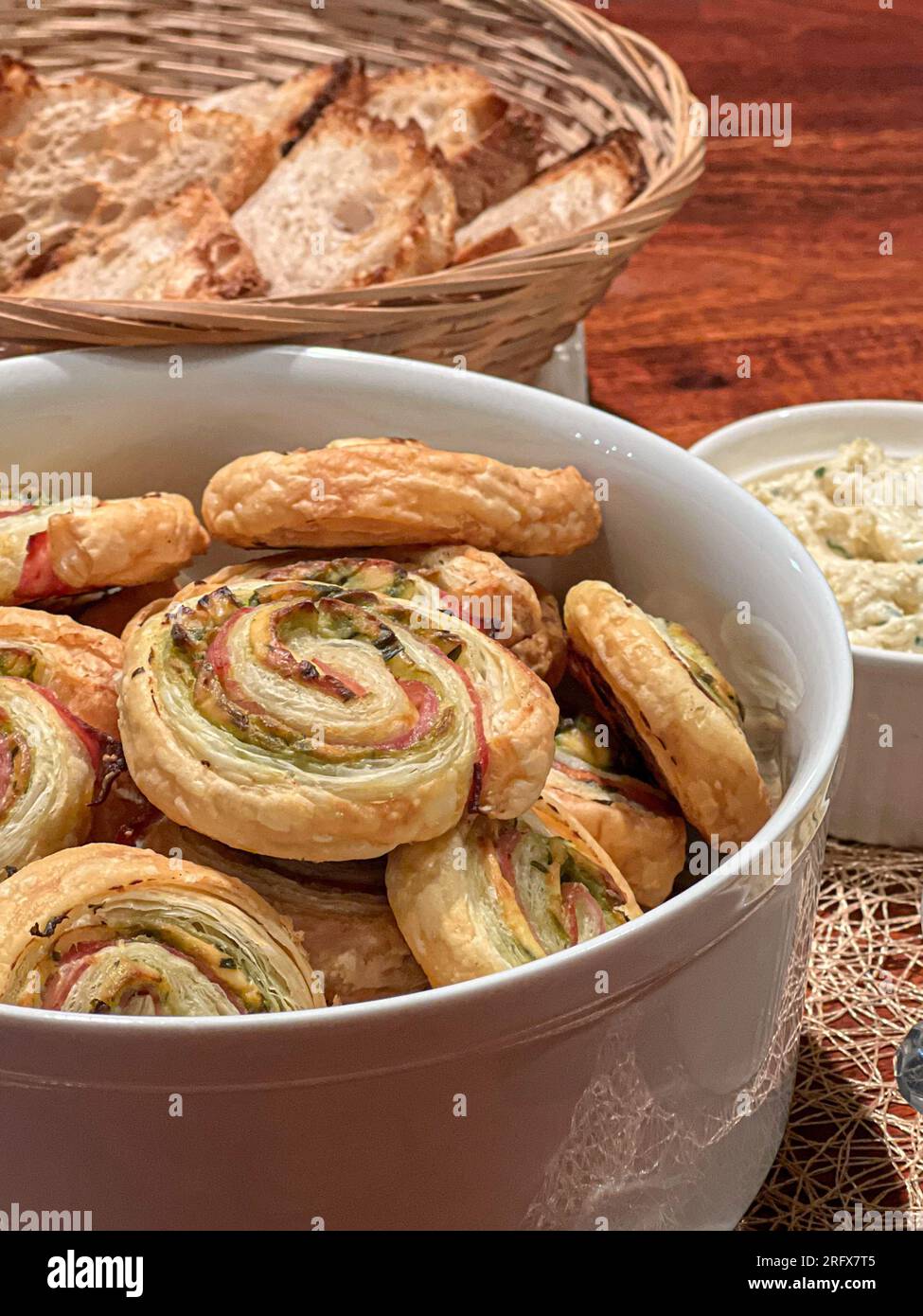 Schlangenförmiges Gebäck mit Kräutern in einer weißen Schüssel. Hausgemachter Snack. Stockfoto