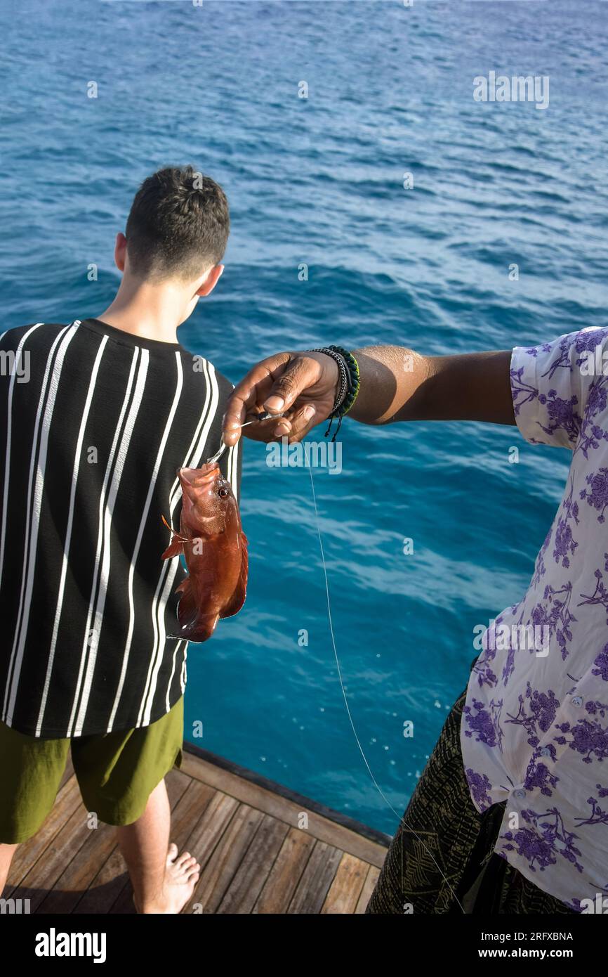 Ein Mann fing einen Fisch im Roten Meer. Angeln, Yachtferien. Fischfang. Angeln im Roten Meer. Nahaufnahme. Selektiver Fokus. Stockfoto