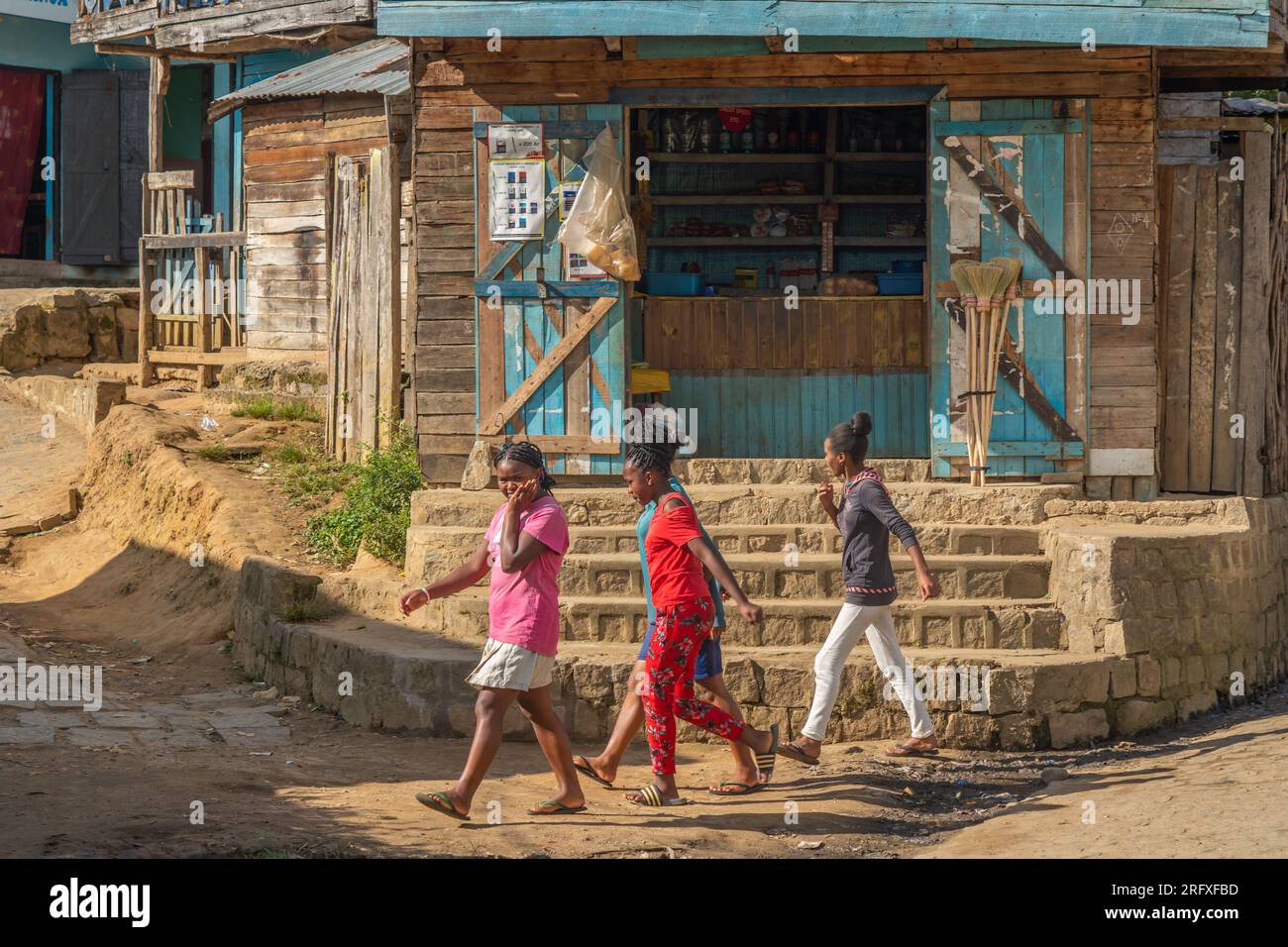 Andasibe, Madagaskar - Mai 26,2023: Jung-madagassische Frauen, die vor einem Holzhaus im Dorf Andasibe spazieren Stockfoto