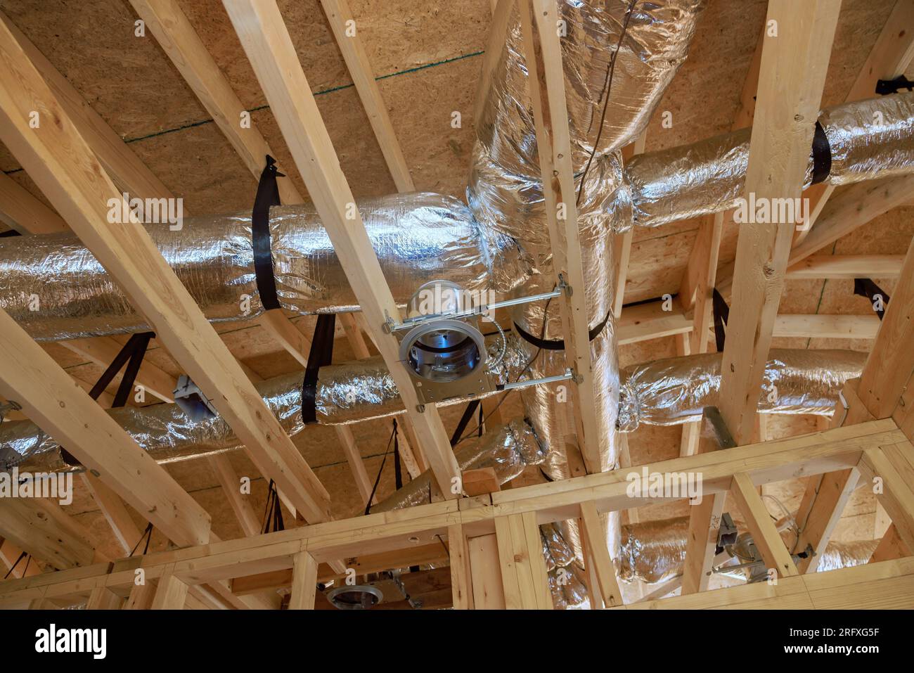 Durch die Installation einer zentralen Klimaanlagen-Klimaanlage wird die Holzbalkendecke im neuen Zuhause hervorgehoben. Stockfoto