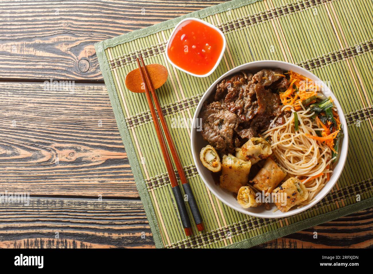 Vietnamesische Rindernudeln Salatbrötchen bo xao ist gefüllt mit frischen Kräutern, herzhaftem Rindfleisch, Gemüse und gebratenen Frühlingsrollen auf dem Tisch. Horizontal oben Stockfoto