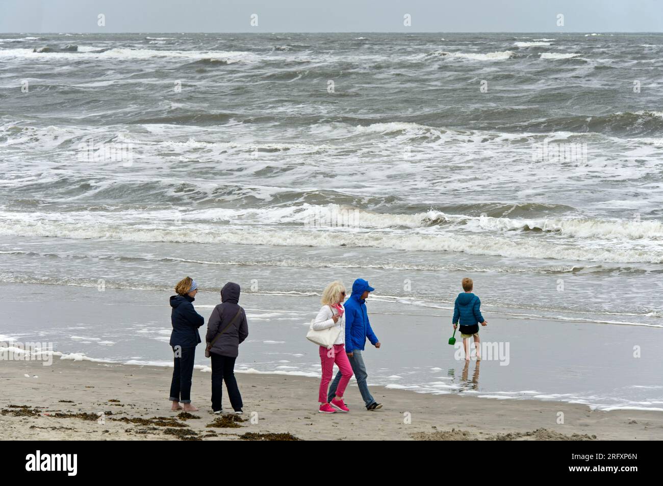 Spaziergänger am Nordseestrand an einem kühlen Sommertag, Langeoog, Ostfriesische Inseln, Niedersachsen, Deutschland Stockfoto