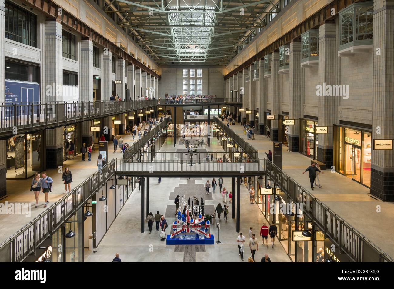 Das Innere des Battersea Power Station zeigt Menschen, die im Rahmen der Umbauarbeiten an Einzelhandelseinheiten vorbeigehen, London, Großbritannien Stockfoto