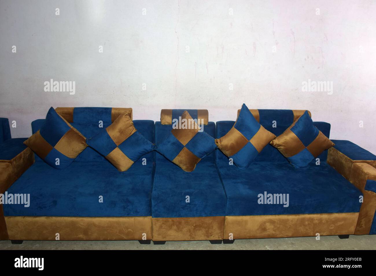 Das Foto zeigt marineblaue und goldene Designs von Sofasets auf dem Haus. Weißer Wandhintergrund Stockfoto