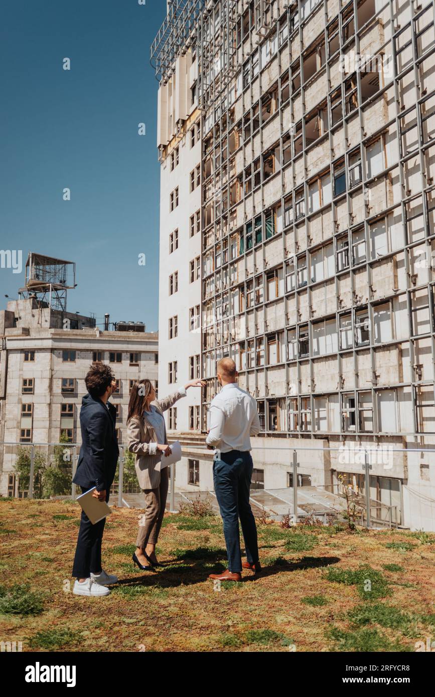 Ein junges, erfolgreiches Architektenteam, das das aktuelle Projekt diskutiert, während es aus der Ferne in der Stadt arbeitet Stockfoto