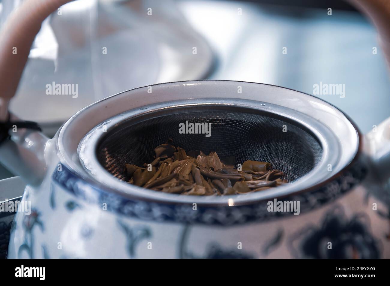 Teekanne mit trockenen Teeblättern auf dem Tisch in der Küche. Stockfoto