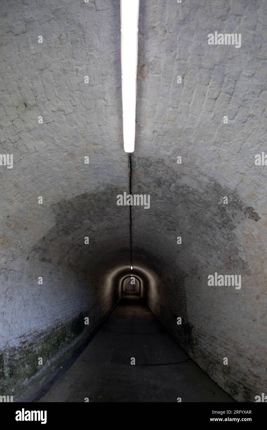Zugang zum Grand Shaft in Dover Western Heights, England, mit fluoreszierendem Streifenlicht an der Decke. Stockfoto