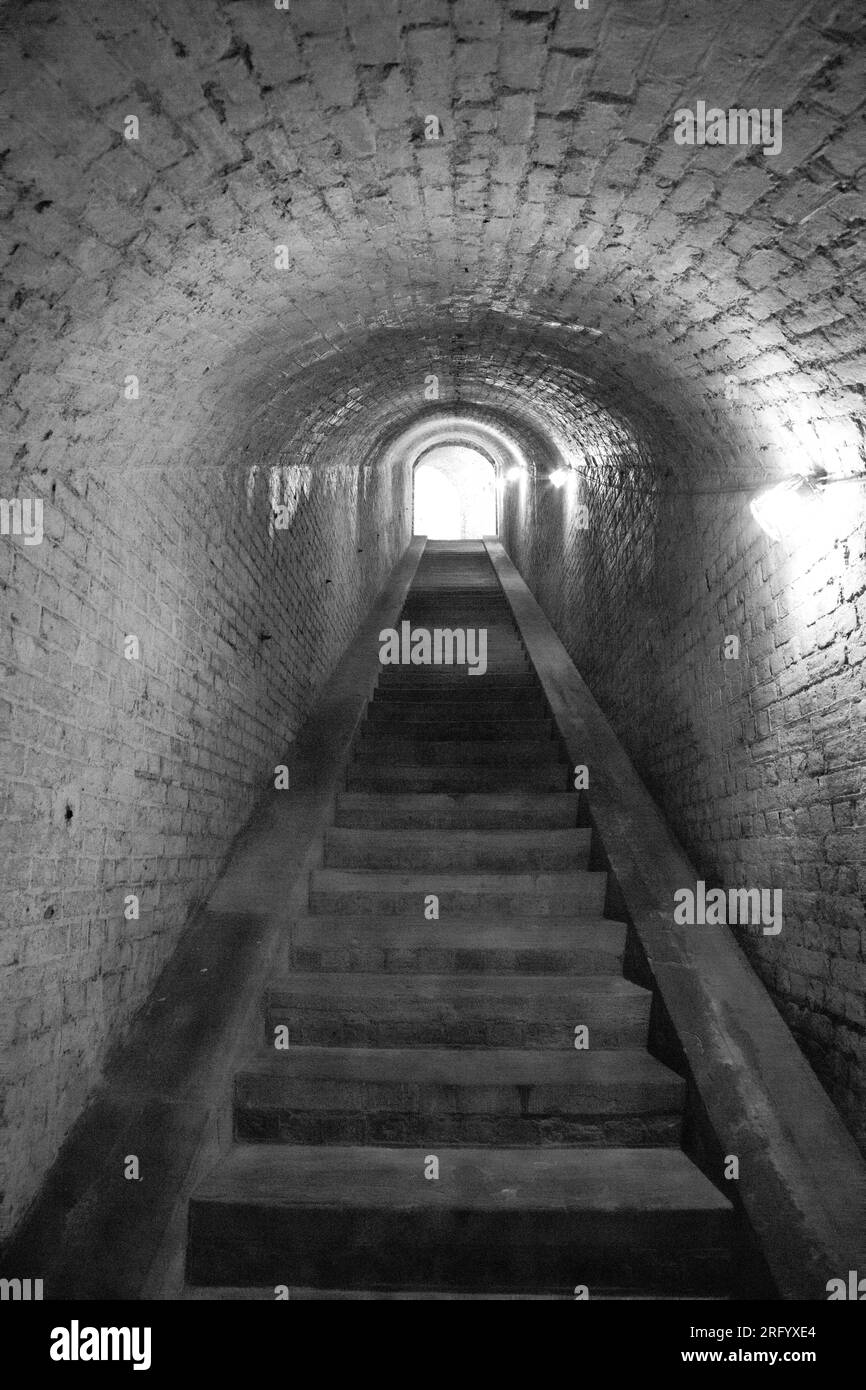 Schwarzweißfoto einer Steintreppe in einem Tunnel in Drop Redoubt Fort, Dover, England. Stockfoto