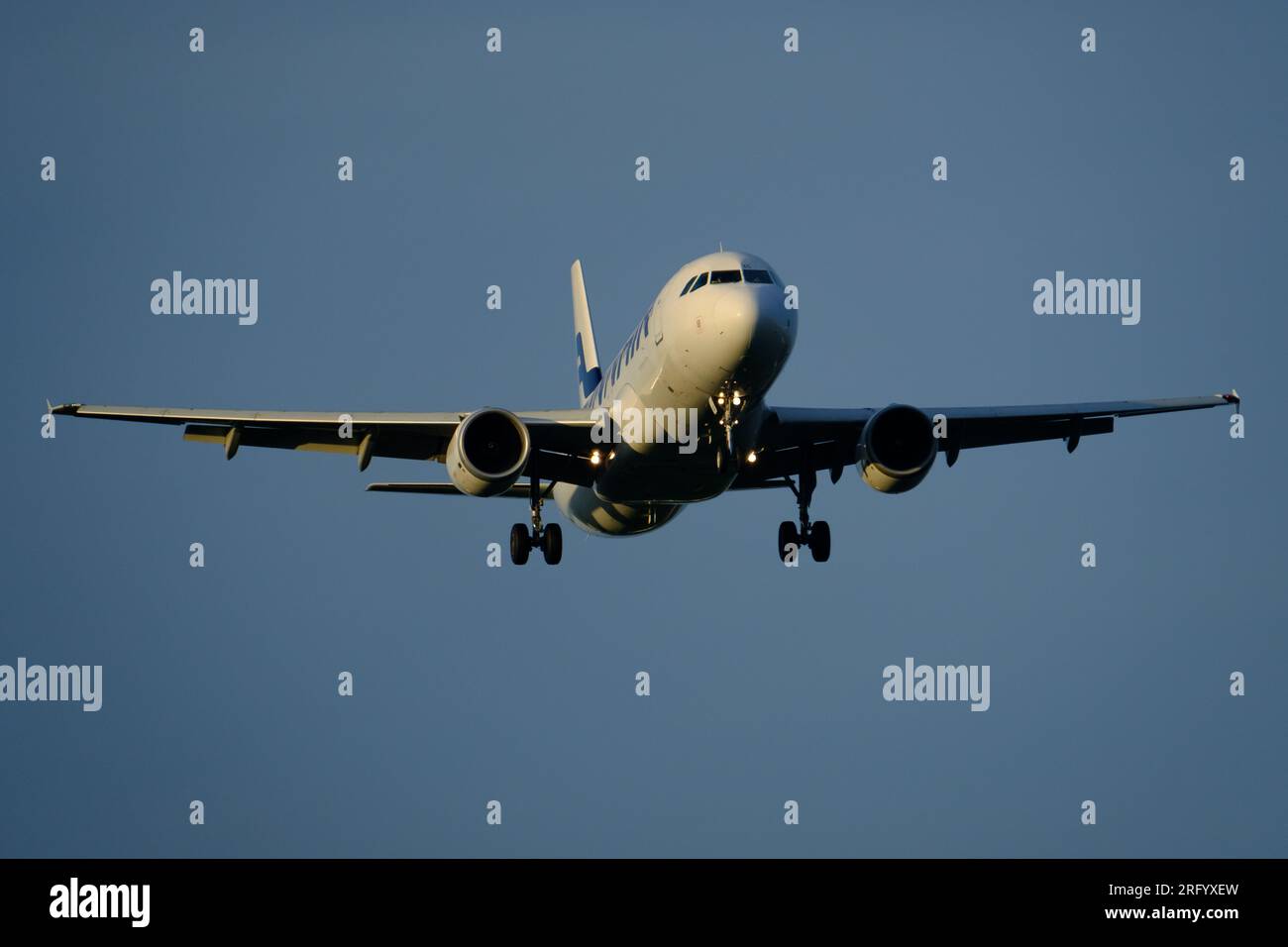 Helsinki/Finnland - 5. AUGUST 2023: Airbus A320 von Finnair nähert sich dem Flughafen bei Sonnenuntergang. Stockfoto