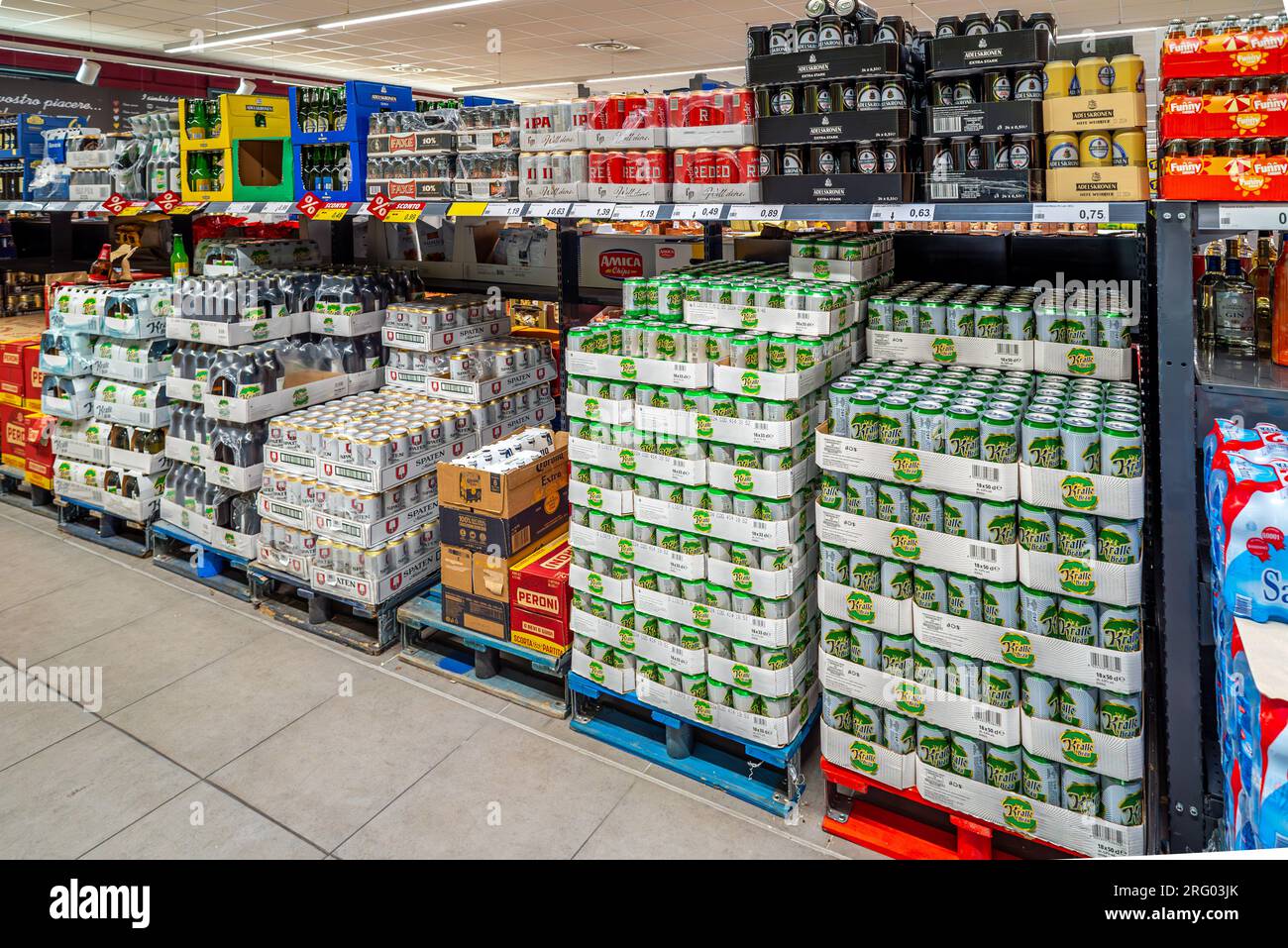 Italien - 05. August 2023: Bierdosen verschiedener Typen und Marken, die auf Paletten gestapelt werden und im italienischen Discounter zu günstigen Preisen verkauft werden können Stockfoto