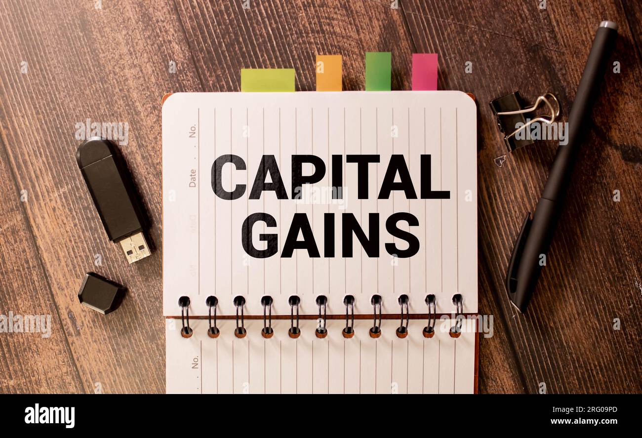Geschäftskonzept. Auf den Finanzplänen liegen ein Stift und ein Schild mit der Aufschrift "Kapitalgewinn". Stockfoto
