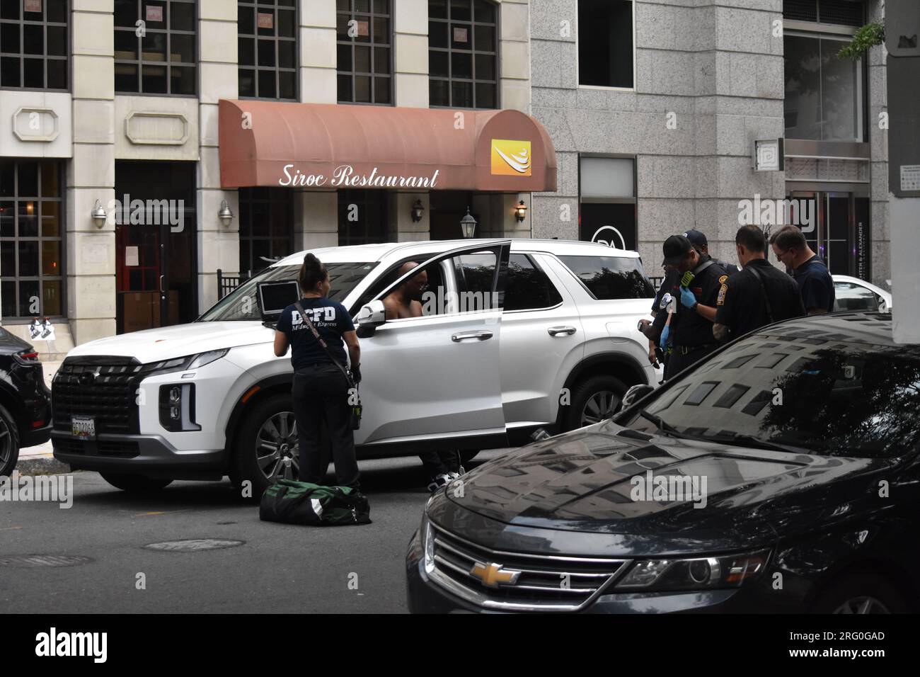 Washington, Usa. 06. Aug. 2023. Person, die am Tatort von Polizeibeamten und medizinischem Notfallpersonal erstochen wurde. Eine Messerstecheruntersuchung in Washington, eine Person, die ein Fahrzeug mit Uber-Markierungen fuhr, wurde im 900. Block der 15. Straße, NW, erstochen. Die Polizei sucht drei schwarze Frauen und zwei schwarze Männer in einer goldenen 4-Türlimousine. Der Geheimdienst der Vereinigten Staaten reagierte und unterstützte die MPD-Offiziere. Kredit: SOPA Images Limited/Alamy Live News Stockfoto