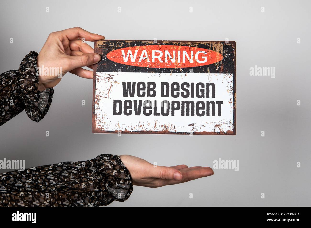 Entwicklungskonzept Für Web-Design. Warnschild mit Text in Frauenhänden. Stockfoto