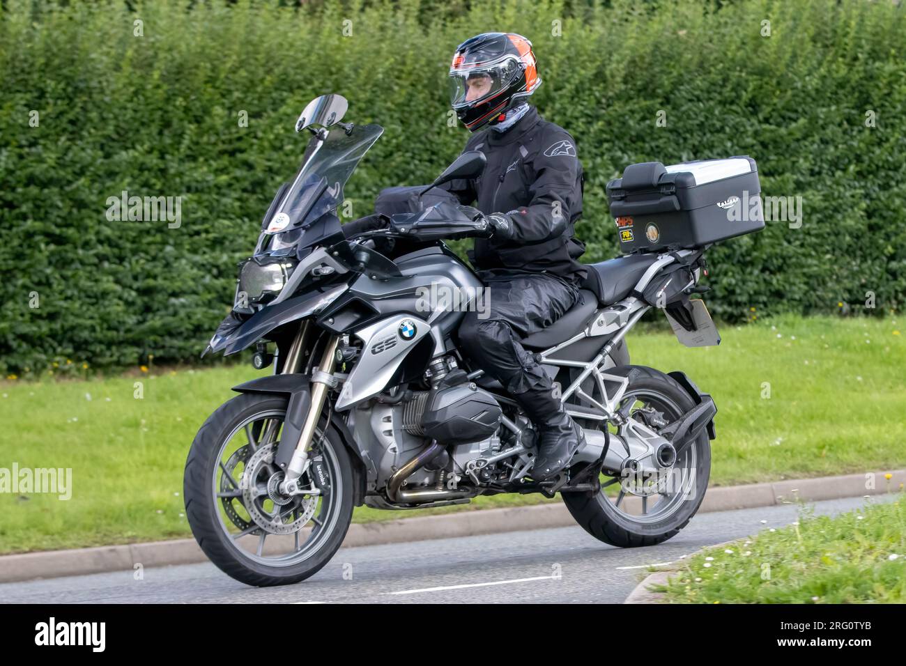Whittlebury, Northants., Großbritannien - 6. 2023. August. BMW GS 1200motorcycle Motorrad fährt durch ein englisches Dorf. Stockfoto
