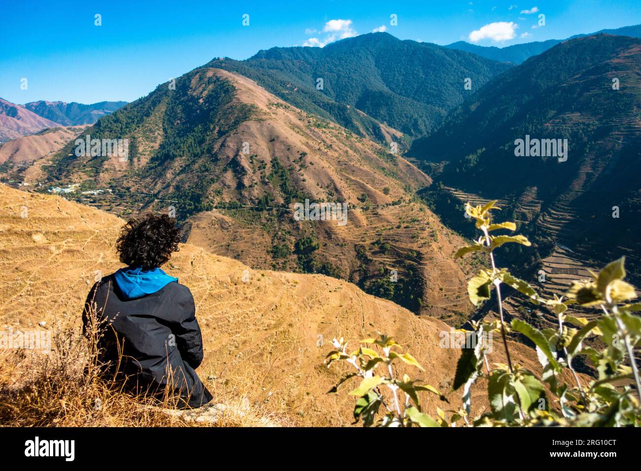 Oktober 14. 2022, Uttarakhand Indien. Einsamer Mann mit fließendem Haar, der die atemberaubende Landschaft des Himalaya-Berges genießt. Ruhiger Moment inmitten der Natur. Stockfoto