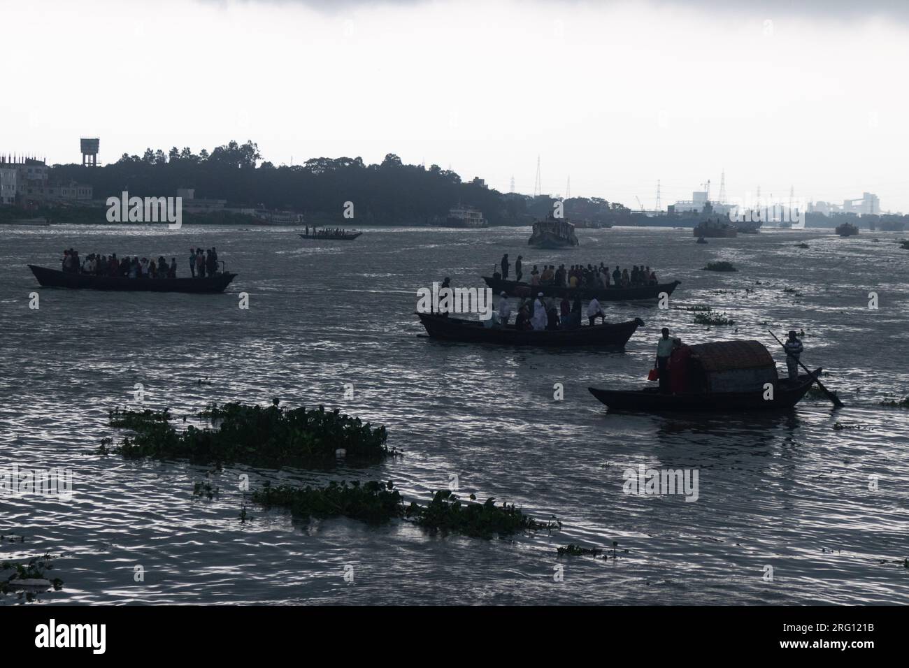 Narayanganj, Dhaka, Bangladesch. 7. Aug. 2023. Die Bewohner überqueren den Shitalakhya River an regnerischen Tagen in Narayanganj, Bangladesch, mit hölzernen Booten. Die Monsunzeit bringt heftige Regenfälle ins Land. Tatsächlich treten etwa 80 % der jährlichen Niederschläge in Bangladesch von Juni bis Oktober auf, und am Ende der Monsunsaison ist fast ein Drittel des Landes unter Wasser. Bangladesch ist ein sehr feuchtes Land, in dem im Durchschnitt etwa 2.200 Millimeter (mm) Niederschlag pro Jahr zu verzeichnen sind. (Kreditbild: © Joy Saha/ZUMA Press Wire) NUR REDAKTIONELLE VERWENDUNG! Nicht für den kommerziellen GEBRAUCH! Stockfoto