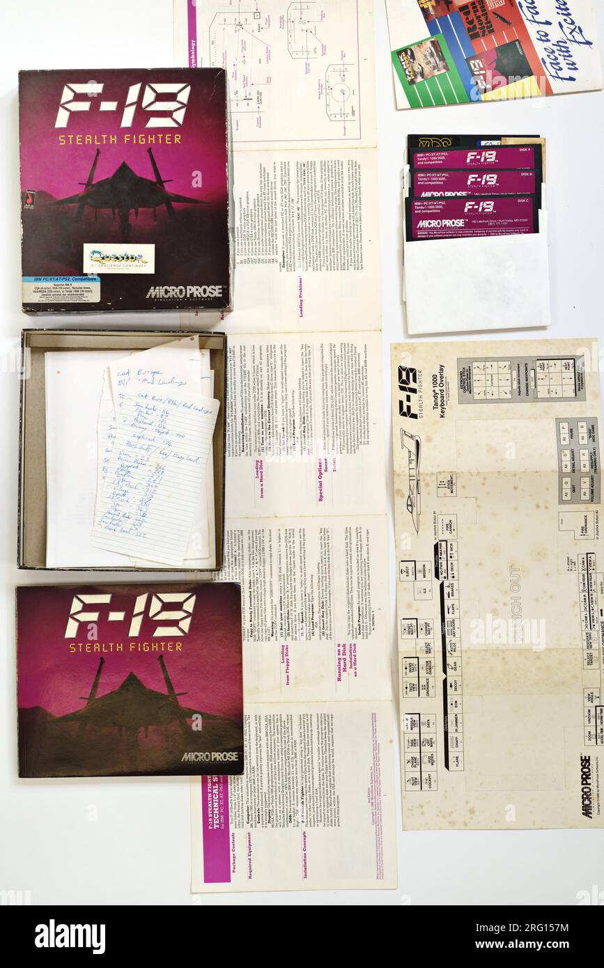 Flatlay des Inhalts des F-19 Stealth Fighter - Kampfsimulator; 1988 MS-DOS Computerspiel Cover Art und Verpackungsdesign. Stockfoto