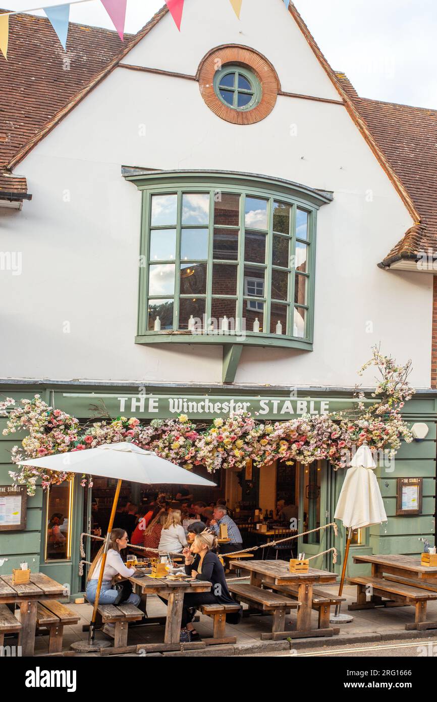 Im Winchester Stall Pub und Restaurant in der Hampshire-Stadt Winchester sitzen Leute draußen, die essen und trinken Stockfoto