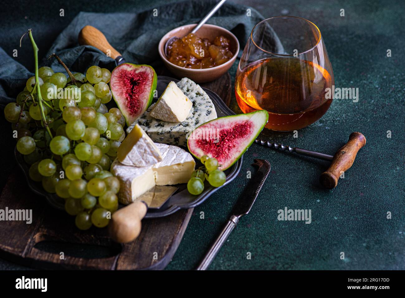 Top View mit leckeren Snacks mit Käse und serviert auf einem Teller auf einem Holzbrett mit Trauben, Feigen und Marmelade Stockfoto