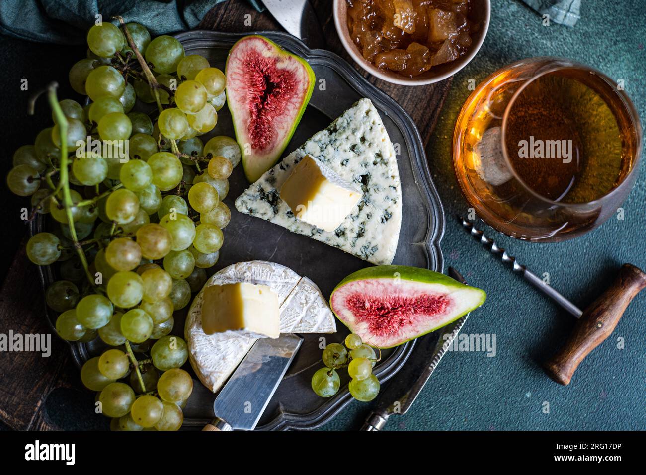 Top View mit leckeren Snacks mit Käse und serviert auf einem Teller auf einem Holzbrett mit Trauben, Feigen und Marmelade Stockfoto