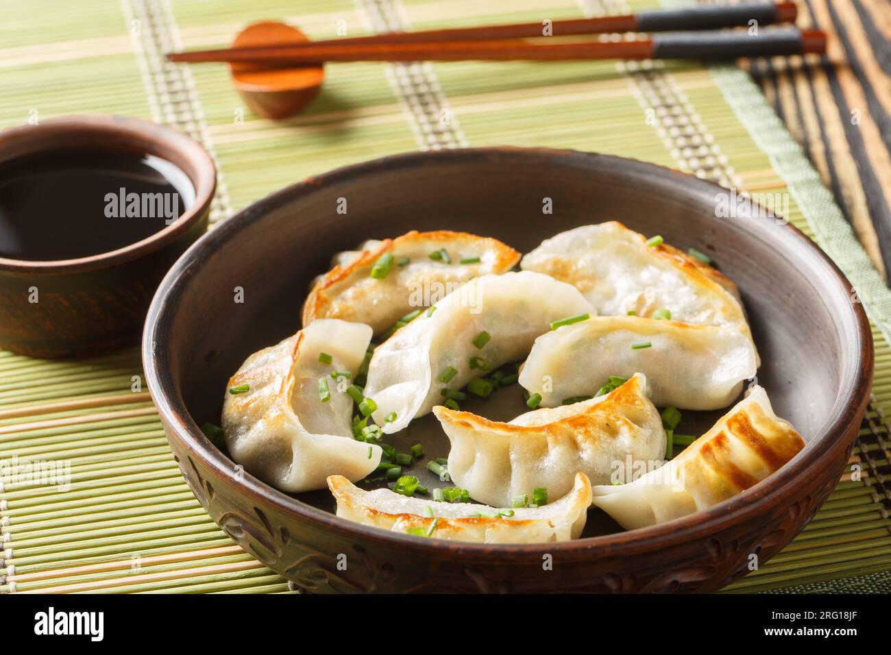 Gyoza oder japanische Knödel mit Sojasauce auf dem Teller auf dem Tisch. Horizontal Stockfoto