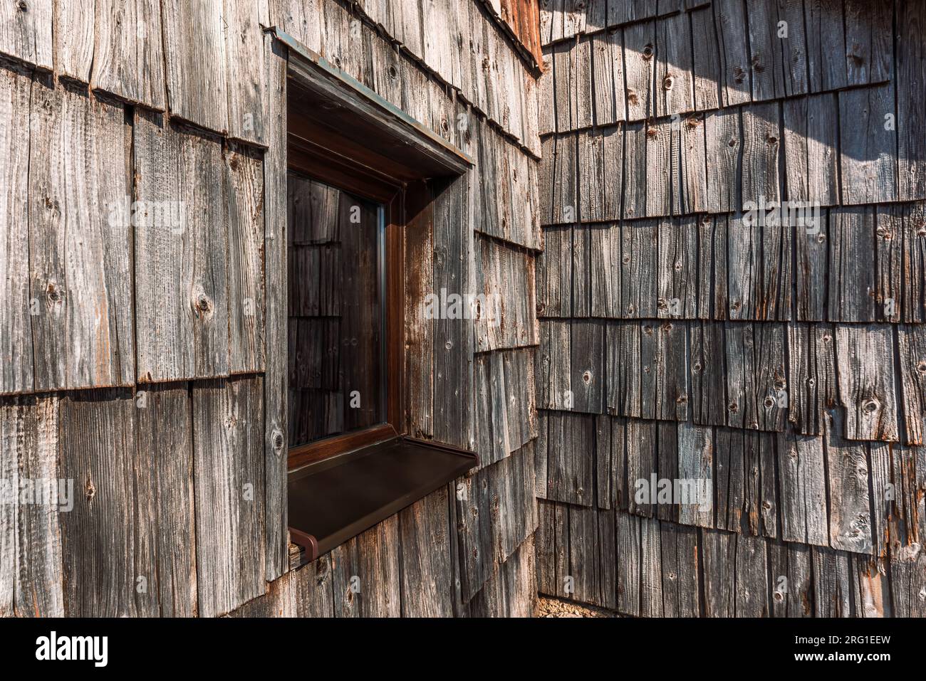 Slowenische Hüttenfenster und abgenutzte Holzgeflieste Fassade, selektiver Fokus Stockfoto