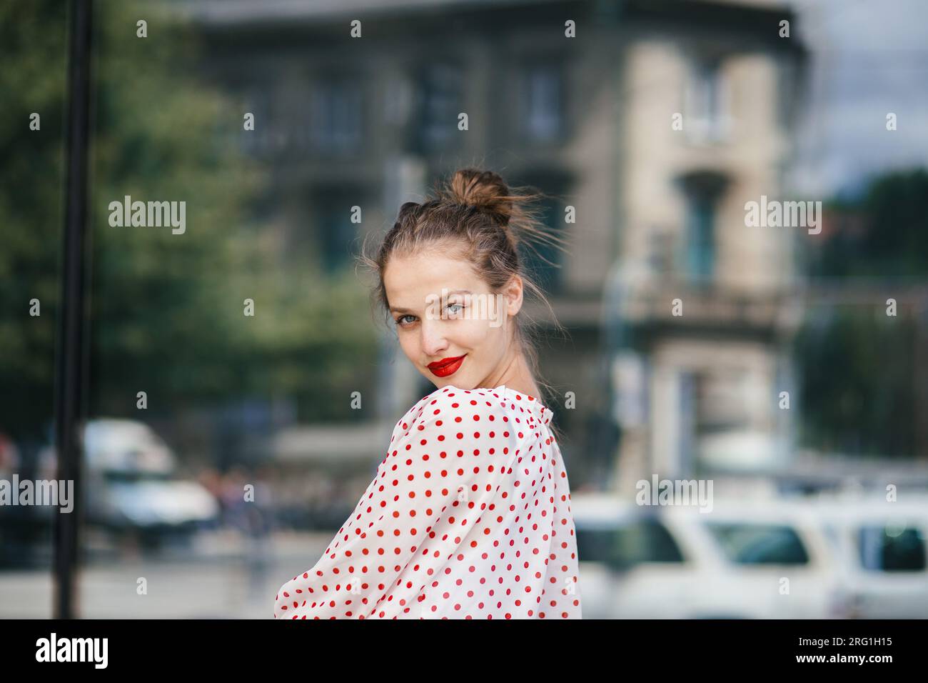 Junge schöne Frau in der Stadt, die roten Lippenstift trägt Stockfoto