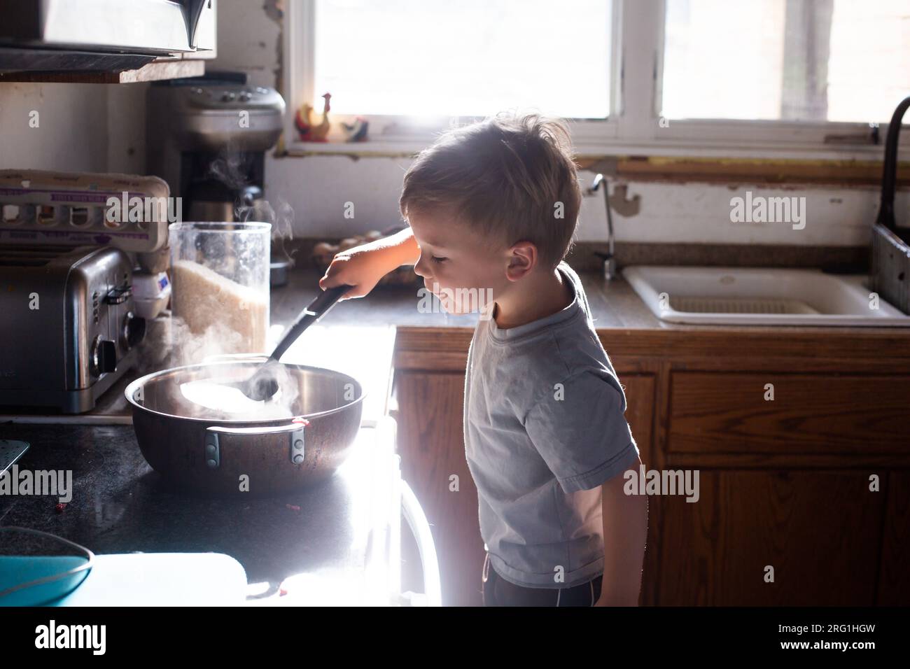 Ein Junge, der beim Kochen hilft Stockfoto