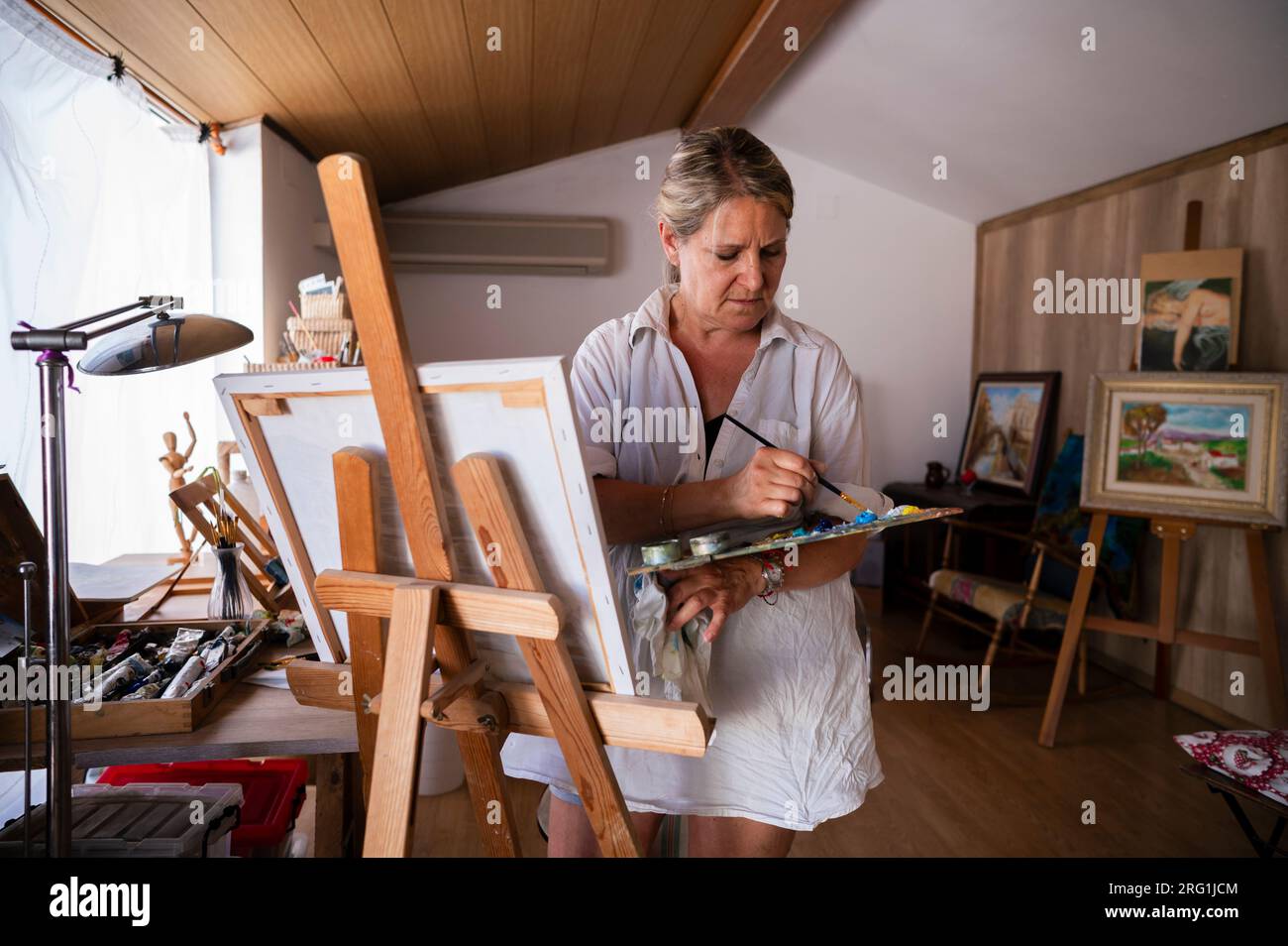 Vorderansicht einer Seniorin, die ein Bild malt. Stockfoto