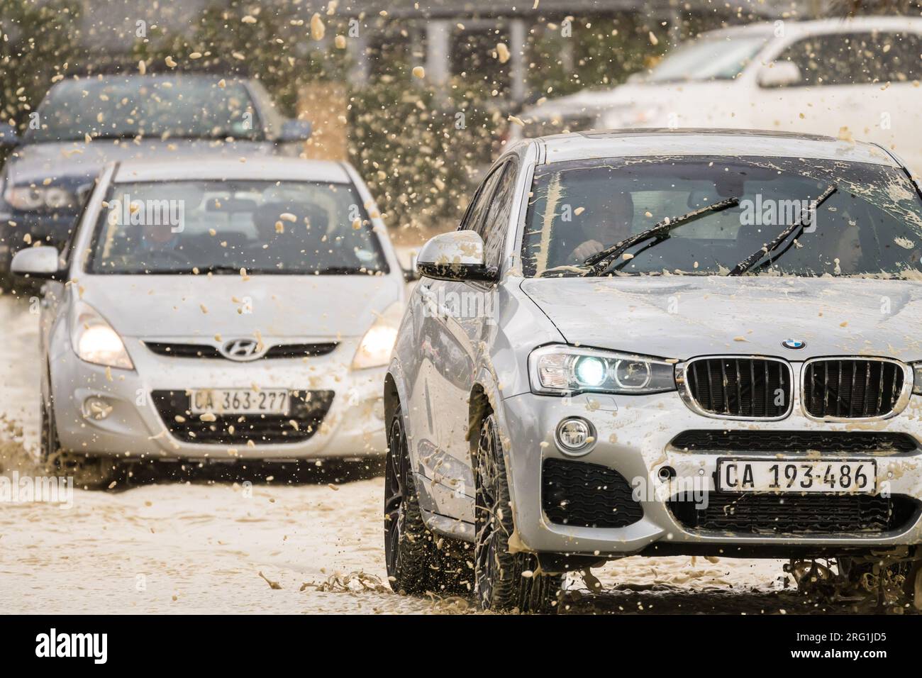 Autos, Verkehr, Fahrzeuge fahren durch winterliche Sturmwetter in Kapstadt, Südafrika Konzeptklima und saisonale Fahrbedingungen Stockfoto