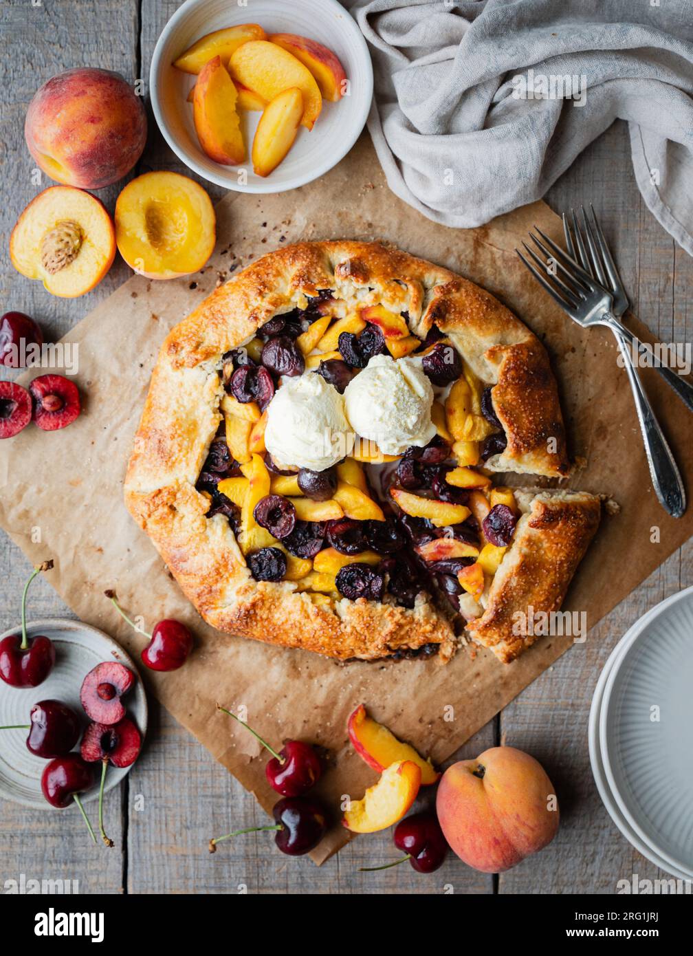 Blick von oben auf frische Pfirsich- und Kirschgalette mit Eiscreme. Stockfoto