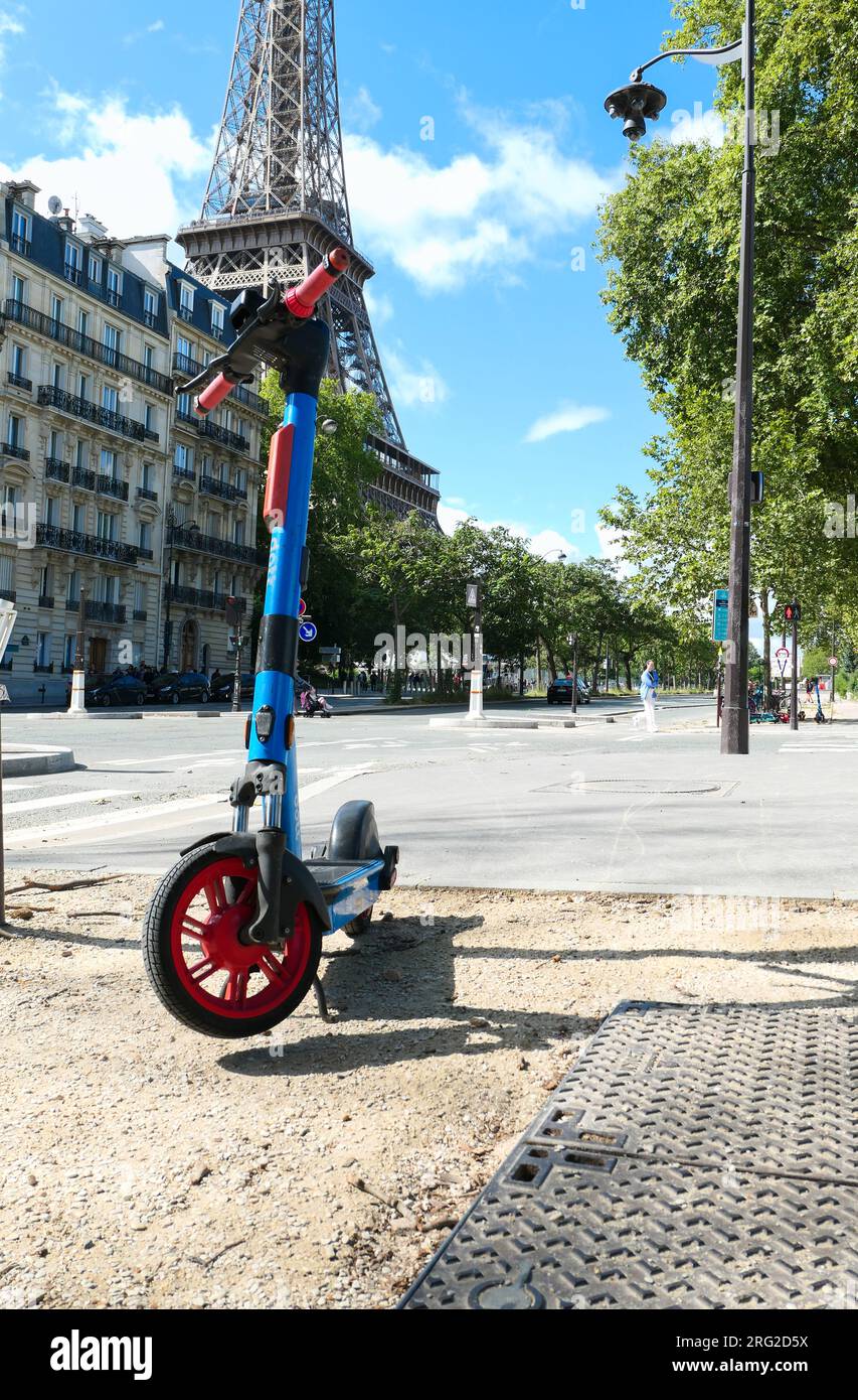 Paris, Frankreich. August 06. 2023. Selbstbedienungs-Elektro-Roller in einer Pariser Straße. Eiffelturm im Hintergrund. Stockfoto