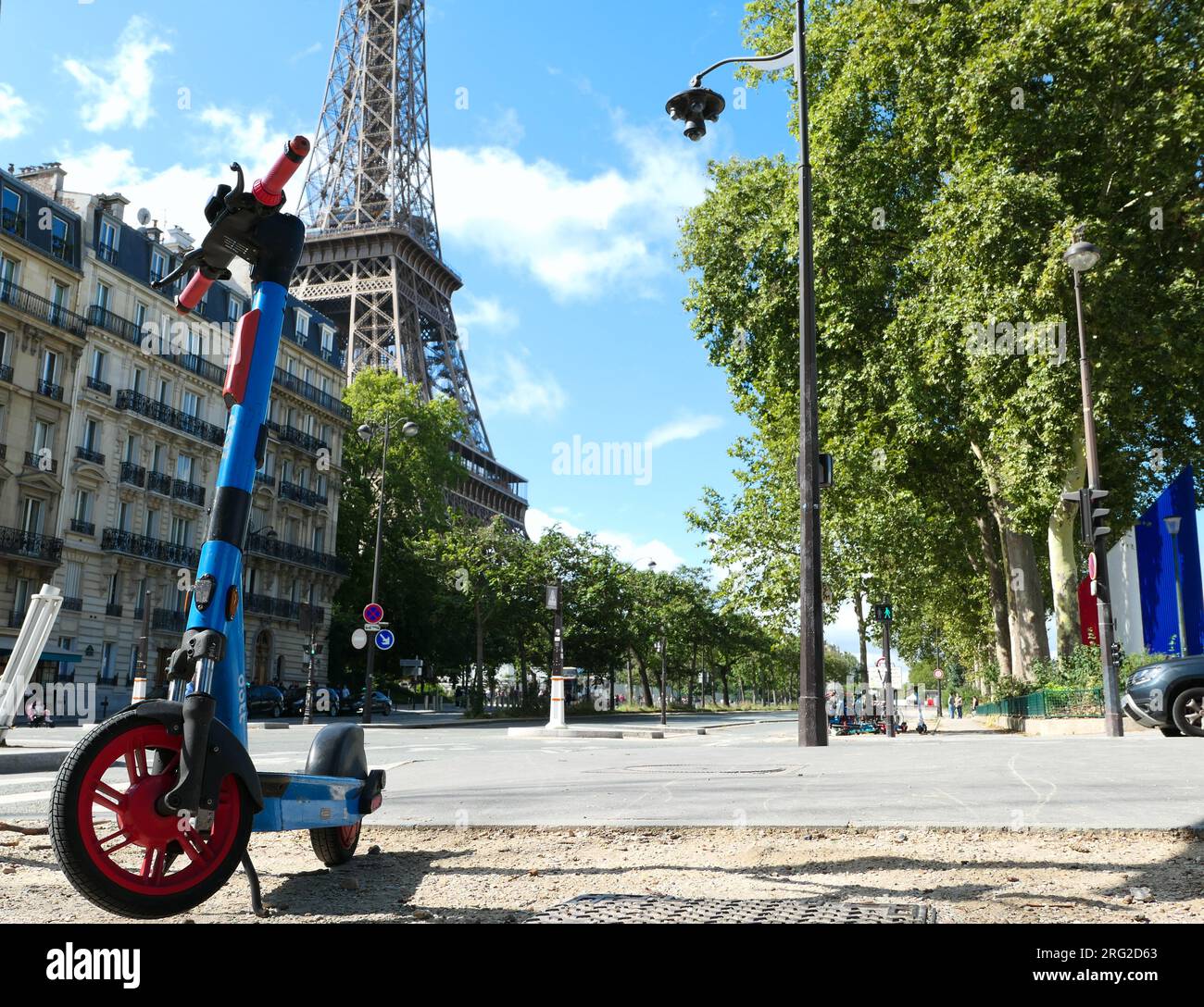 Paris, Frankreich. August 06. 2023. Selbstbedienungs-Elektro-Roller in einer Pariser Straße. Eiffelturm im Hintergrund. Stockfoto