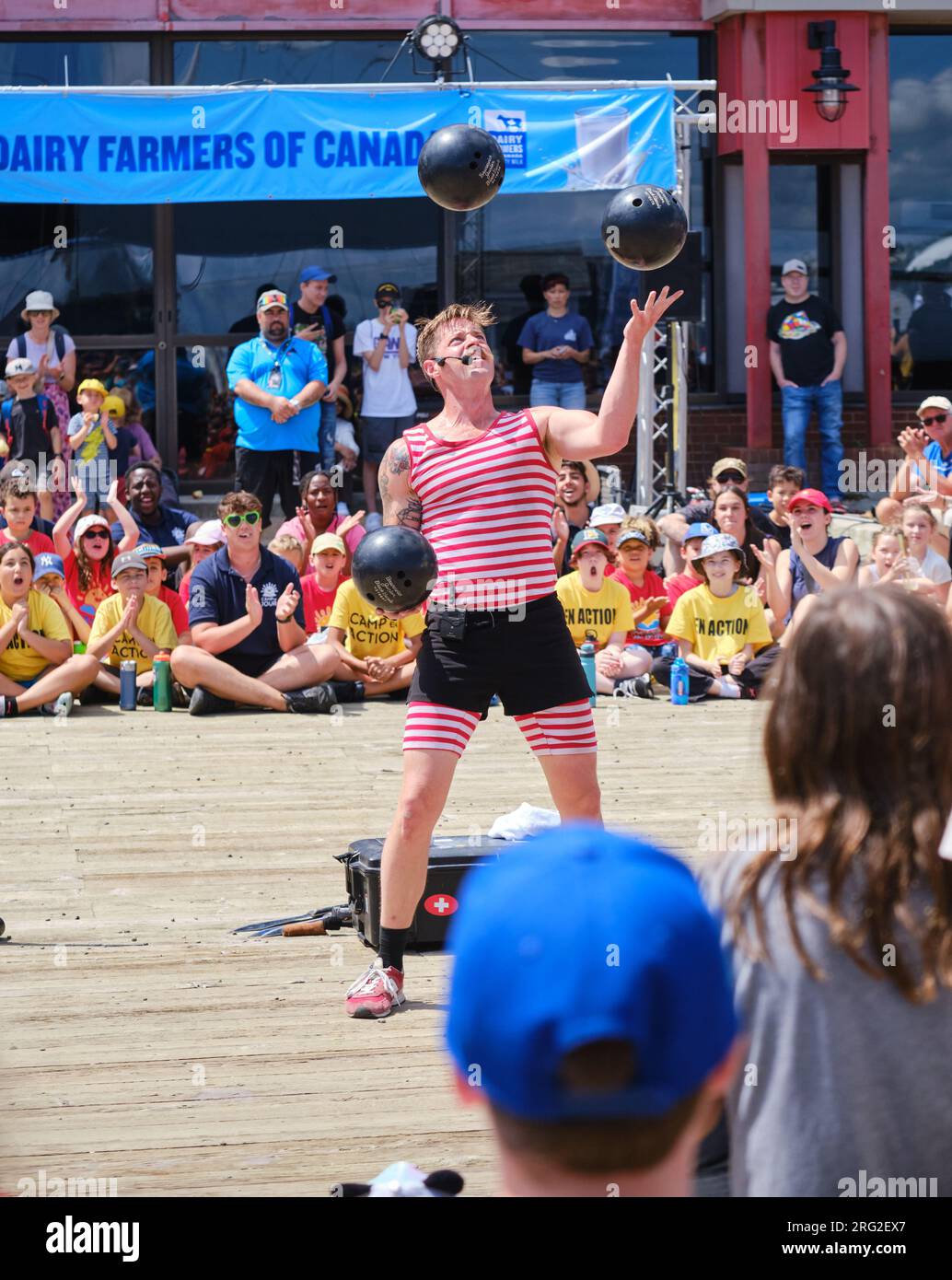 Der Strongman-Busker Mighty Mike jongliert beim Halifax Busker Festival 2023 mit drei Bowlingbällen, um das Publikum zu begeistern Stockfoto