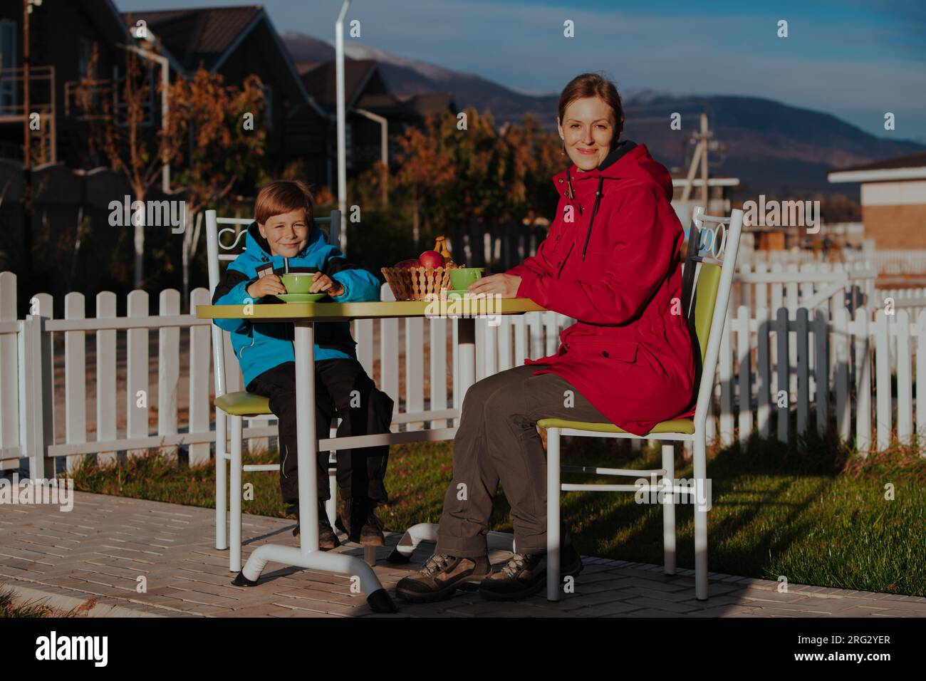 Mutter und Sohn trinken Tee auf dem Hof eines Landhauses Stockfoto