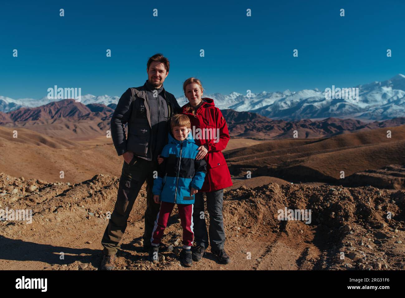 Vater, Mutter und Sohn, die im Herbst im Hintergrund in den Bergen posieren Stockfoto