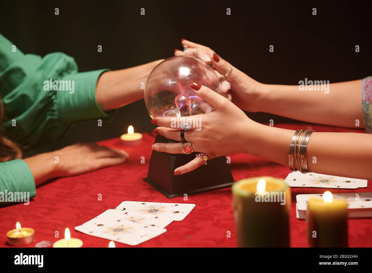 Der Wahrsager bittet den Klienten, die Kristallkugel anzufassen Stockfoto