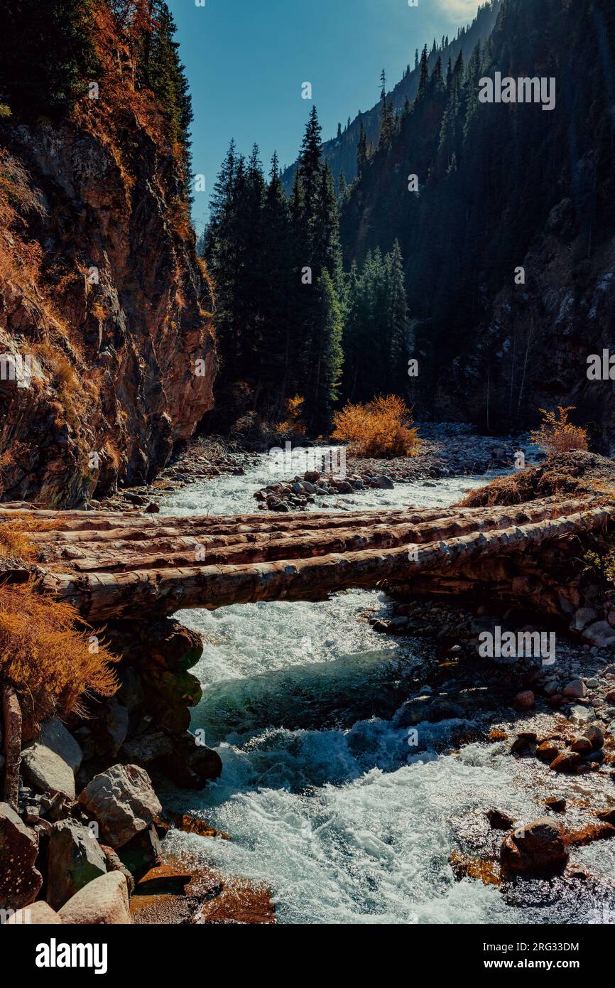 Herbstliche Berglandschaft mit Holzbrücke über den Fluss Stockfoto