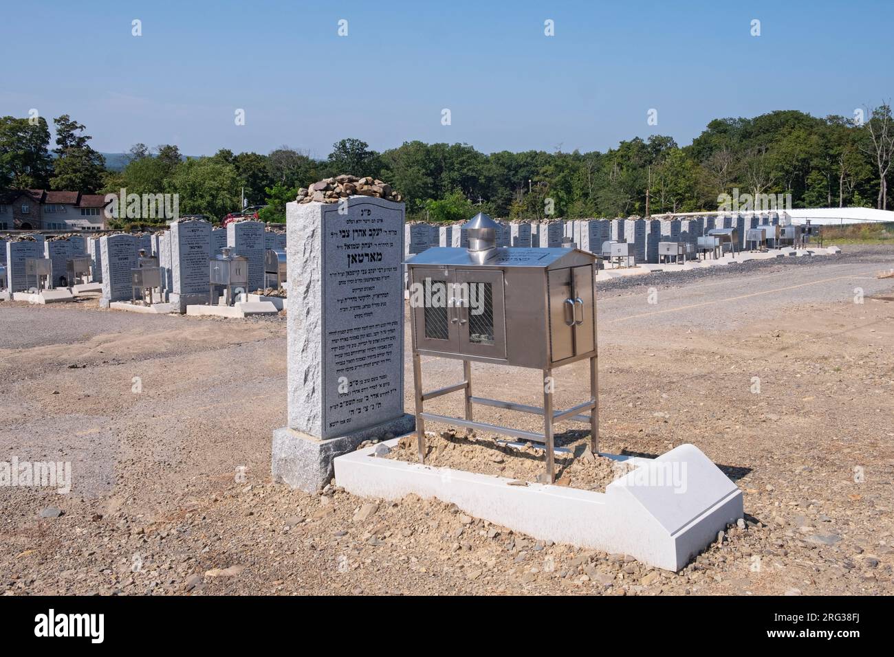 Grabsteine auf dem alten Satmarer Friedhof. Die meisten sind mit Steinen bedeckt und haben silberne Kerzenhalter. In Kiryas Joel im Staat New York. Stockfoto