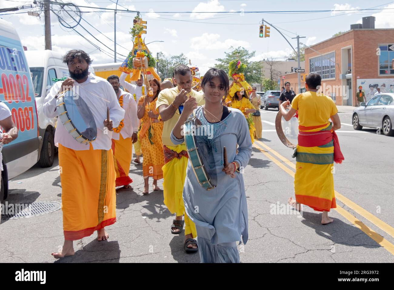 Devout Hindus march, viele barfuß, von ihrem Tempel bis zum Ort ihres Spaziergangs auf heißen Kohlen, auf der 101 Ave in Ozone Park Queens. Stockfoto