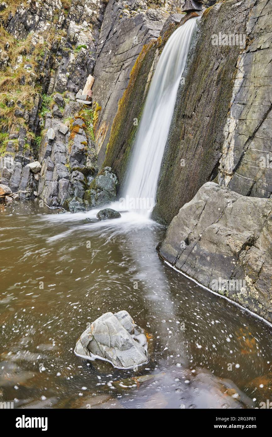 Ein Wasserfall stürzt auf einer senkrechten Klippe an der Küste von Speke's Mill Mouth in der Nähe des Hartland Quay, der Atlantikküste von Devon, Großbritannien, ab. Stockfoto