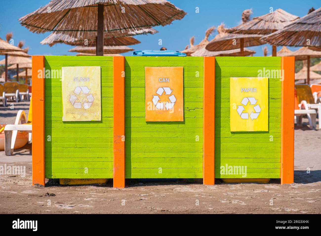 Müllcontainer zum Sammeln von Recyclingmaterial. Abfalltrennung. Separates Abfallsammelglas, Papier und Dose am Strand in Stockfoto