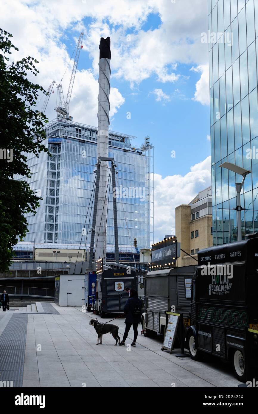 London - 05 29 2022 Uhr: Blick auf einen Teil des Merchant Square mit Straßenverkaufswagen und Kamin des St. Mary's Hospital Stockfoto