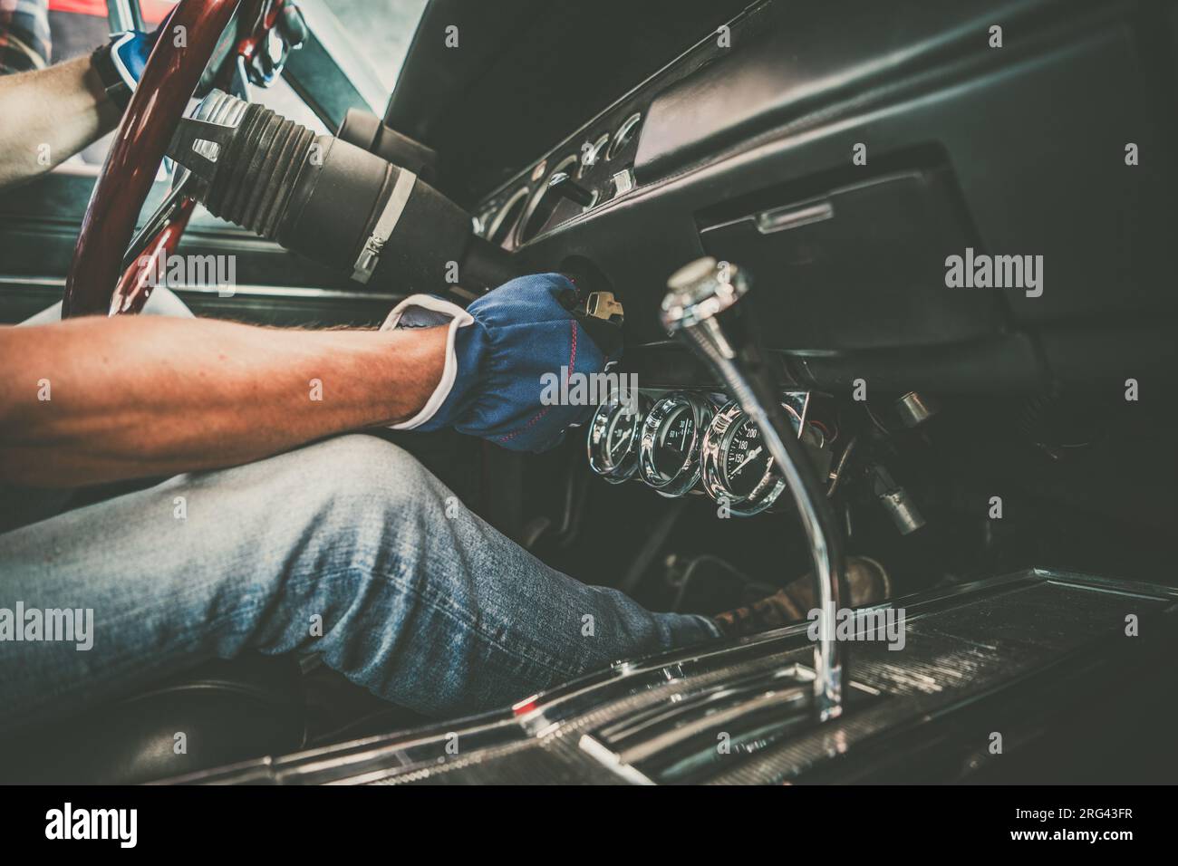 Classic Cars professioneller Mechaniker, der ein Fahrzeug auf dem Sitz untersucht Stockfoto