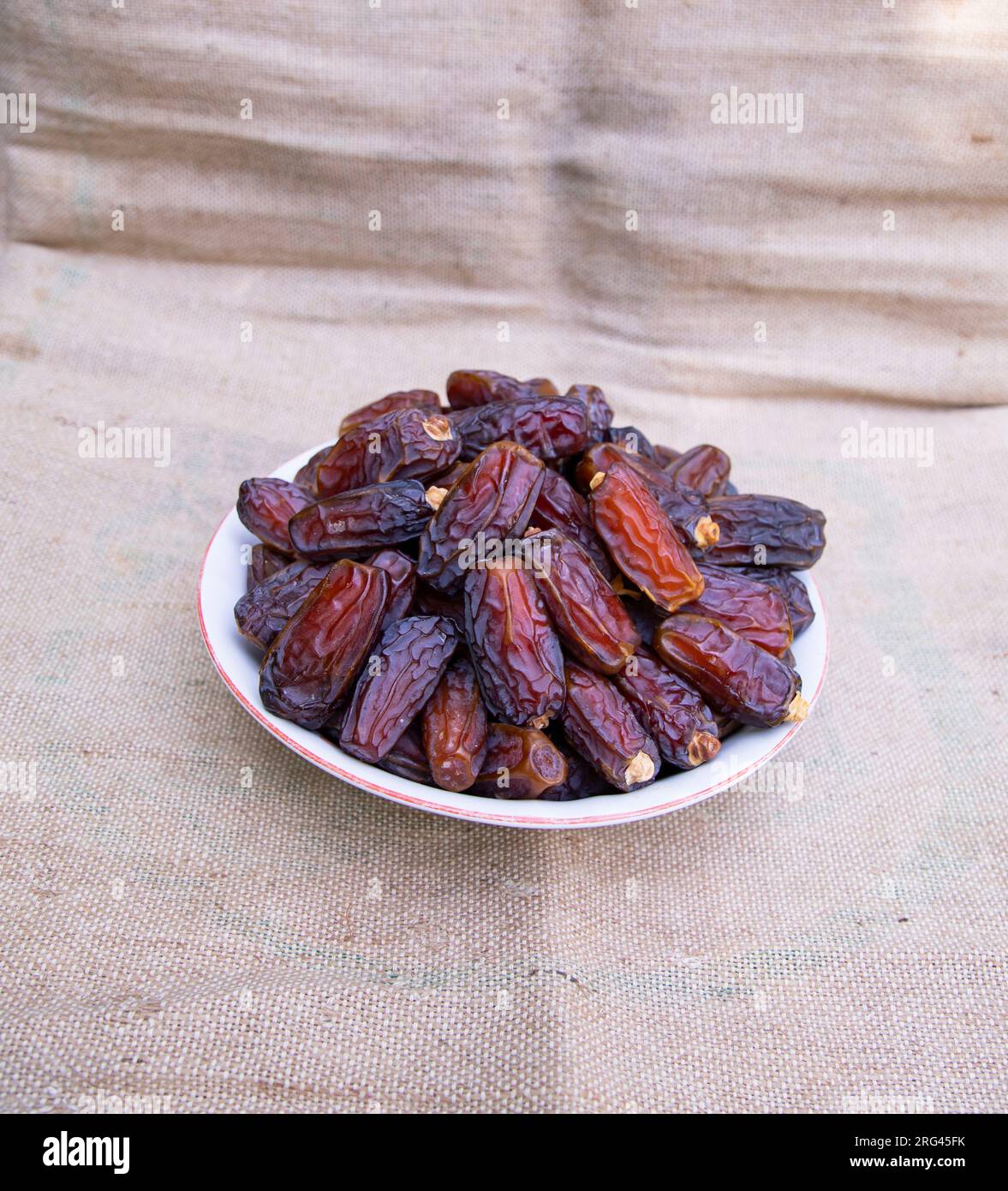 Eine Schüssel köstliches Date-Obst auf Jutefaserstoff Stockfoto