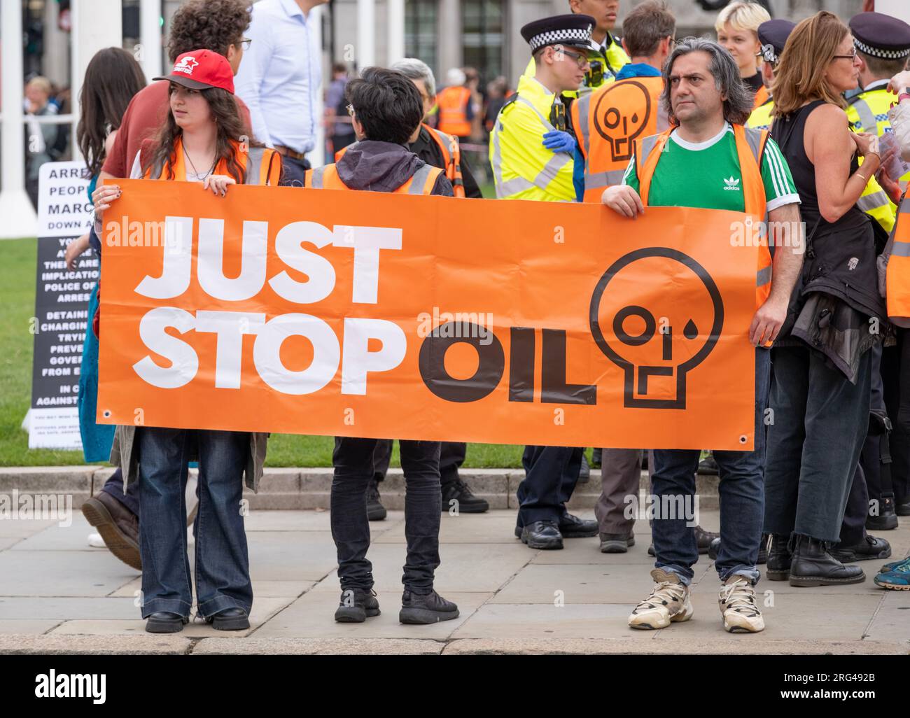 Just Stop Oil-Aktivisten mit großem Banner in Zentral-London, die sich für die Regierung einsetzen, alle zukünftigen Lizenzen und die Produktion fossiler Brennstoffe zu stoppen. Stockfoto