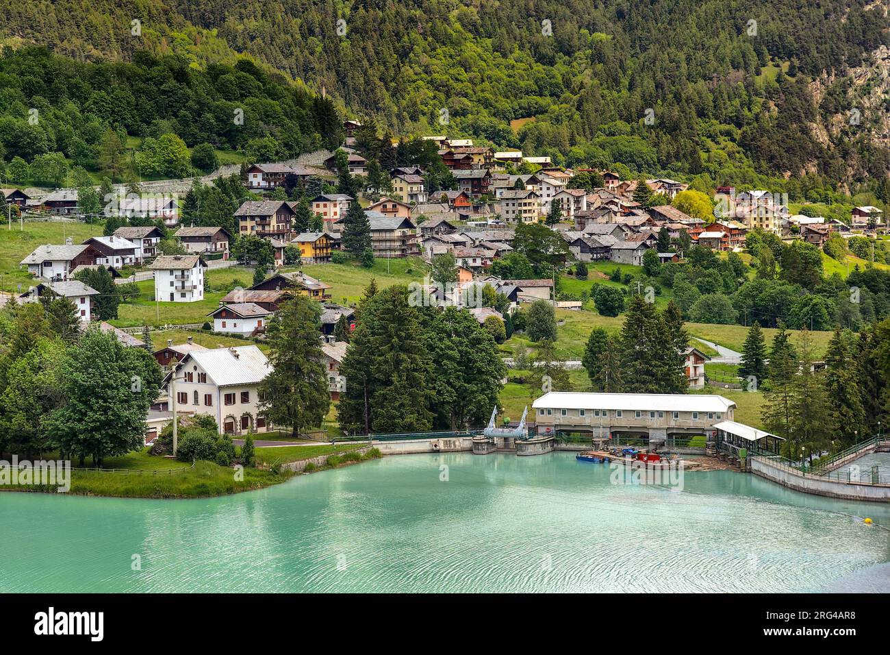 Blick von oben auf den Bergsee Brusson und die kleine Stadt am Fuße der Berge im Aosta-Tal, Italien. Stockfoto