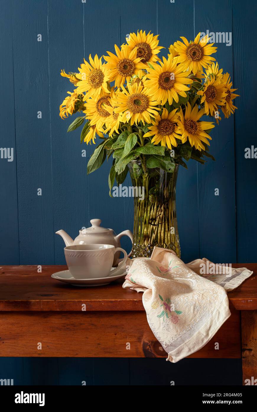 Sonnenblumenstrauß mit Teetasse und Topf in einem rustikalen Stilleben. Stockfoto